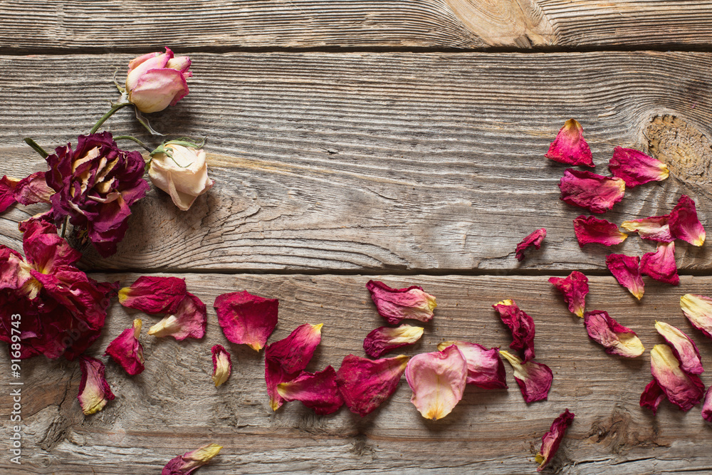 dried rose petals on wooden table dried rose petals on wooden table