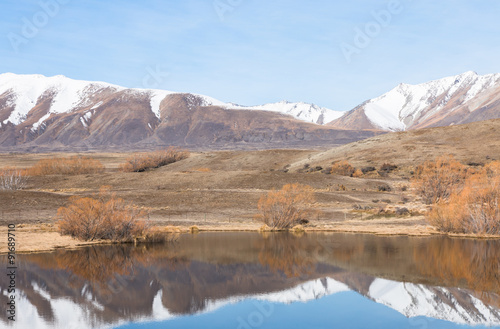 Reflection of snow covered mountains in a small lake