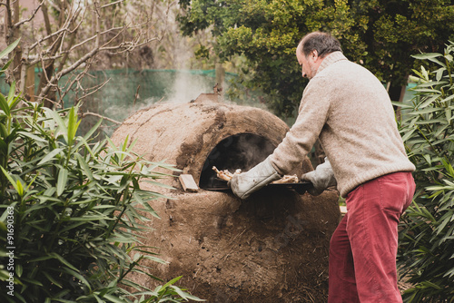 Man cooking forhis family in a clay oven