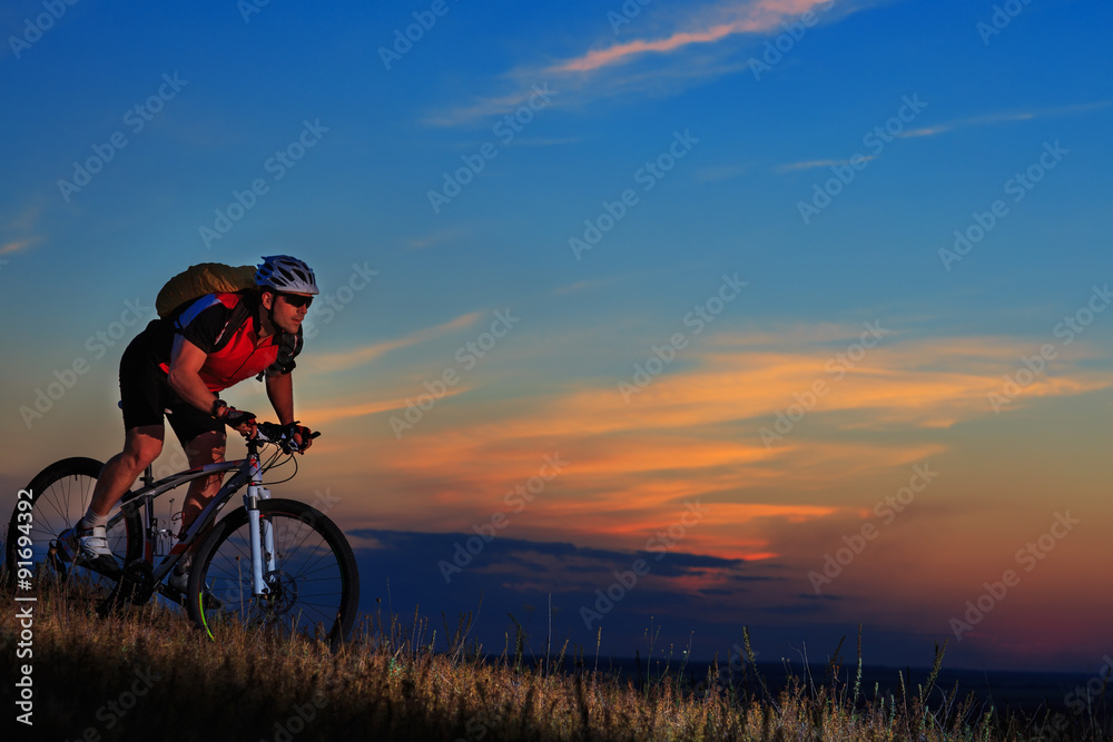 Silhouette of a biker and bicycle on sunset background. Silhouette of a biker and bicycle on sunset background.