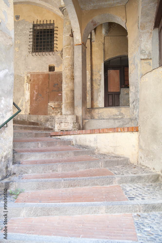 ITALY EMPIRE - JULY 14, 2014: View of the alley with stairs up t ITALY EMPIRE - JULY 14, 2014: View of the alley with stairs up t