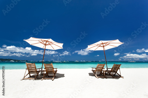 Fototapeta Naklejka Na Ścianę i Meble -  Sun umbrellas and wooden beds on tropical beach