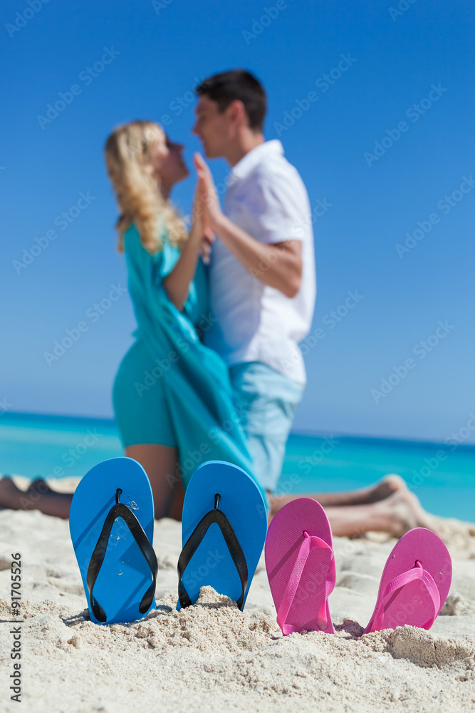 Fototapeta premium Slippers in sandy beach, travel concept