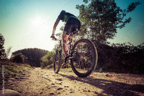 Man riding on a dirty road on a mountain bike photo