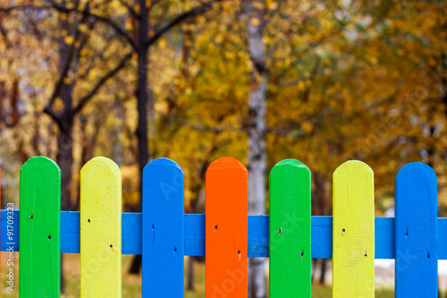 Autumn background with colored fence.