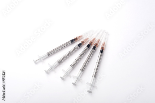 Top view of the five disposable syringes on the white background