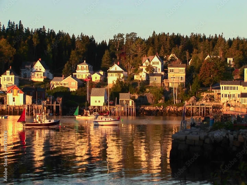 Sailboats are at anchor near a lobster village in Stonington, Maine. Sailboats are at anchor near a lobster village in Stonington, Maine.