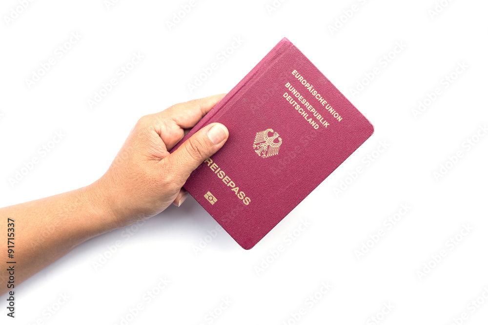 Close up hand holding German passport isolated on white Close up hand holding German passport isolated on white