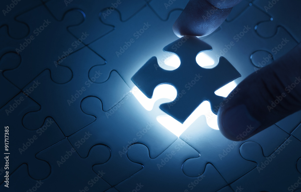 Business concept, male hand putting missing piece of jigsaw puzzle Business concept, male hand putting missing piece of jigsaw puzzle