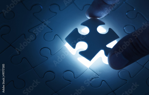 Business concept, male hand putting missing piece of jigsaw puzzle