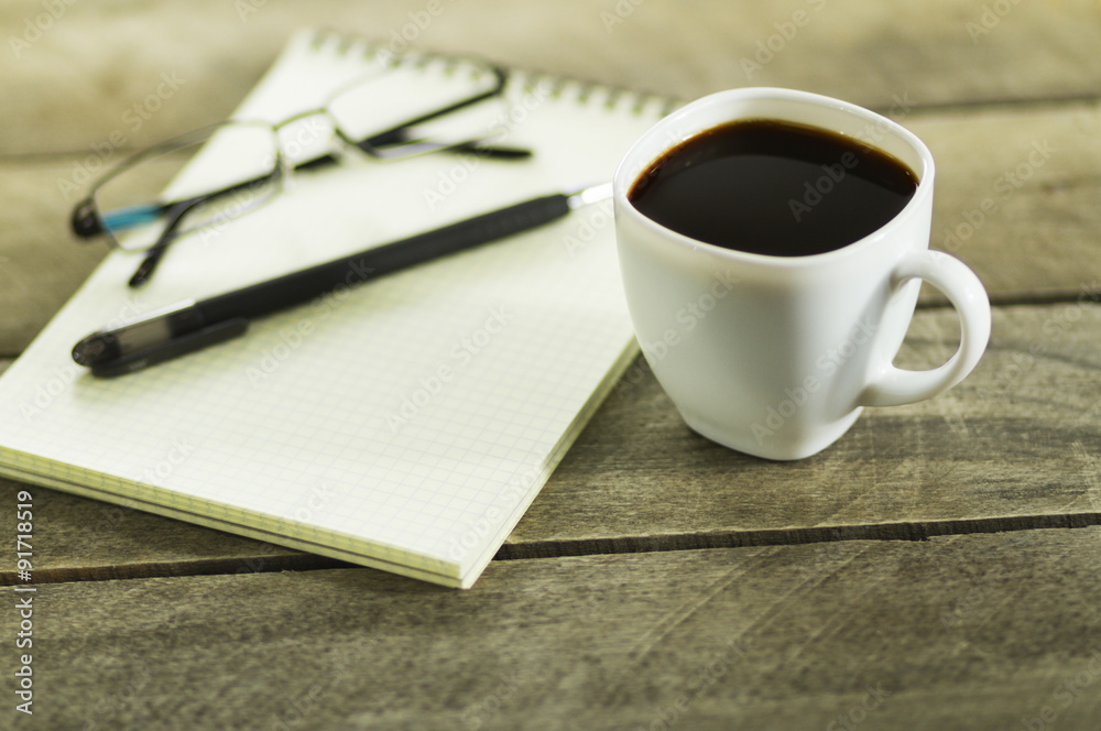 black coffee and notebook on the table black coffee and notebook on the table