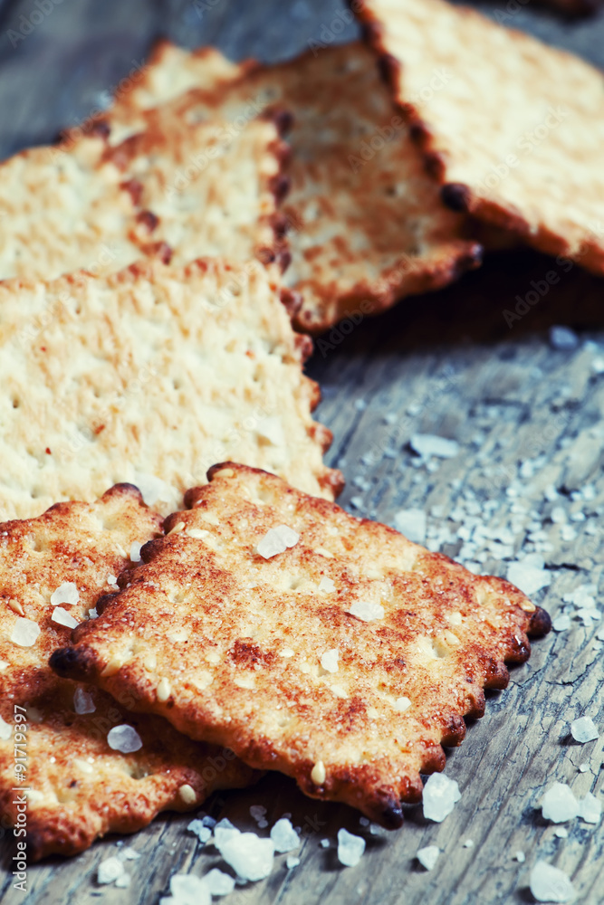 Salty cracker and sea salt on a dark wooden background, toned im Salty cracker and sea salt on a dark wooden background, toned im