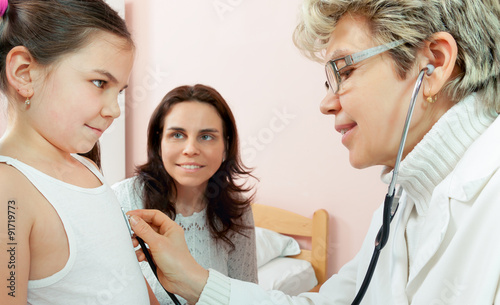 Doctor examining a child in a hospital photo