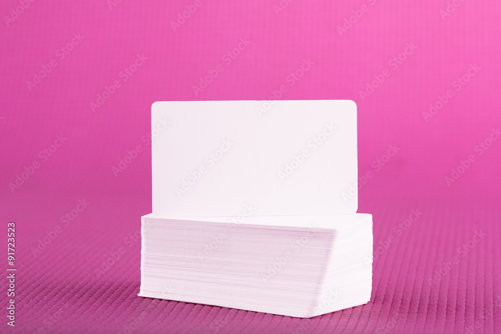 Stack of business cards on pink background
