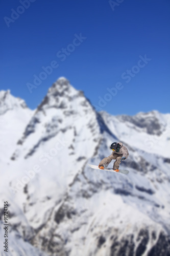 Flying snowboarder on mountains