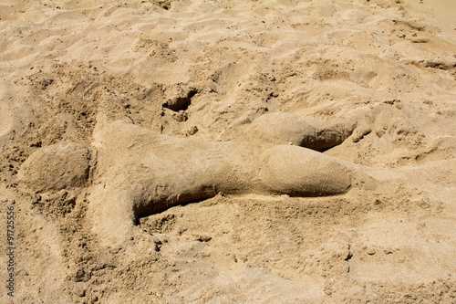 Кипр. Протарас. Пляжная скульптура в виде загорающего человека сделана из песка на пляже детьми.