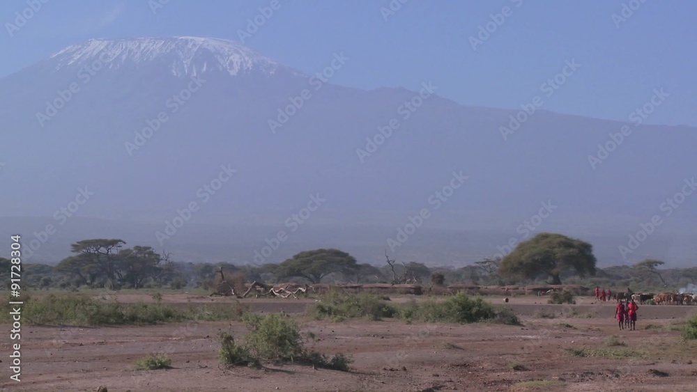 Masai warriors walk in in front of Mt. Kilimanjaro in Tanzania, East Africa. Masai warriors walk in in front of Mt. Kilimanjaro in Tanzania, East Africa.