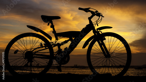 Fototapeta Naklejka Na Ścianę i Meble -  Silhouette of mountain bike with sunset sky beside sea, Thailand