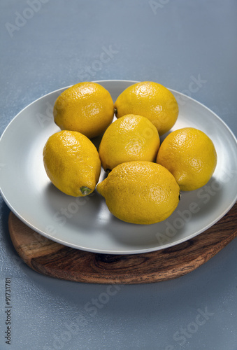 lemons on a plate. on grey