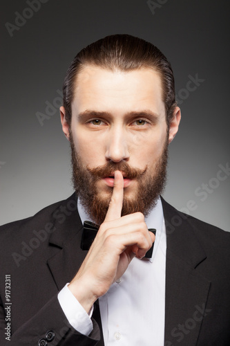 Cheerful young businessman with beard is gesturing