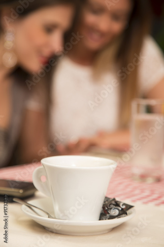 Coffee cup with people in background.