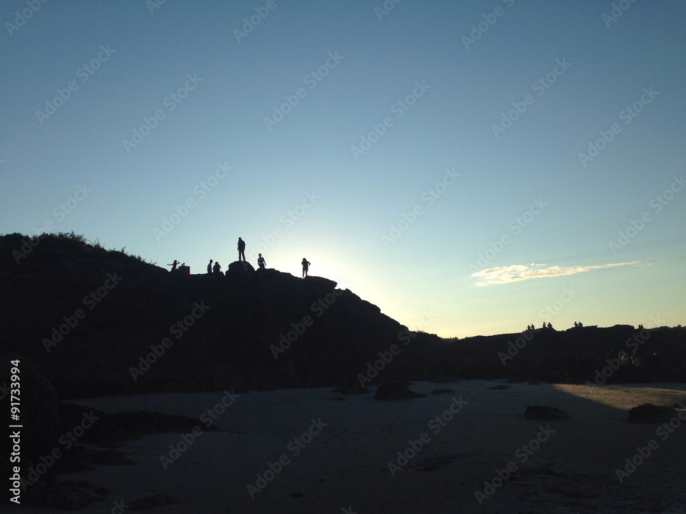 Naklejka premium people's silhouette on top of cliff