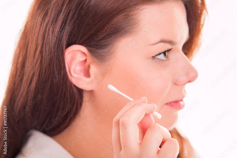 Woman uses cotton ear buds to clean ear
