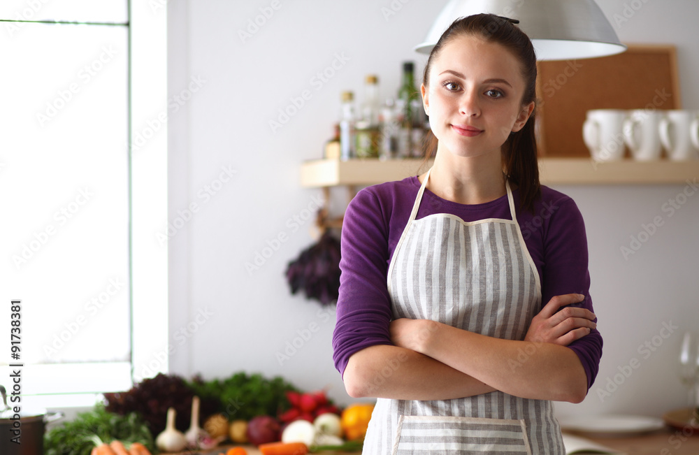 A young woman standing in the kitchen.