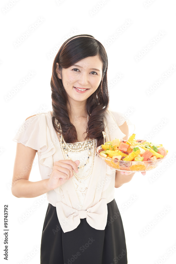 フルーツサラダを食べる女性