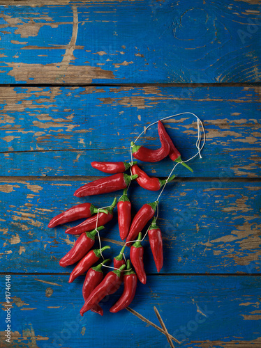 Bunch of red hot peppers on blue table