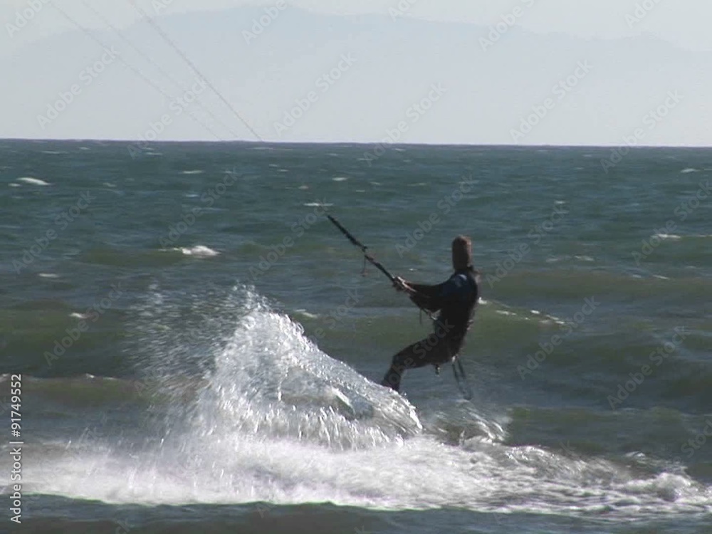 A kite surfer catches air from a wave.
