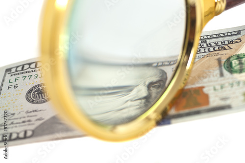 Hundred dollar banknote under magnifying glass isolated