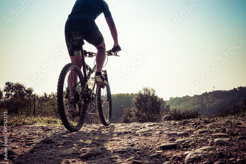 Man riding on a dirty road on a mountain bike 