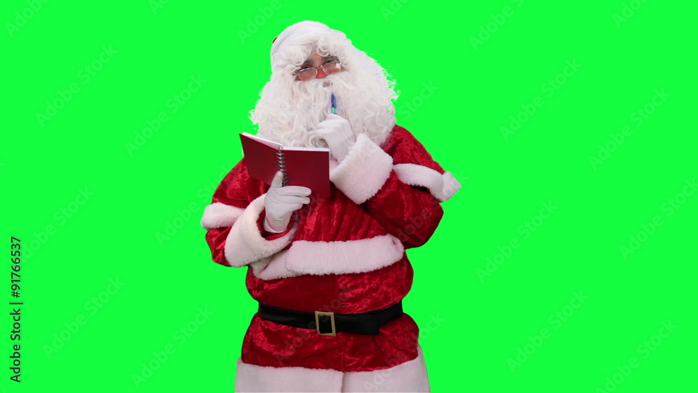 Santa Claus with Notepad in hand chroma key (green screen). Santa makes notes in a red notebook isolated on green
Santa Claus with Notepad in hand chroma key (green screen). Santa makes notes in a red notebook isolated on green