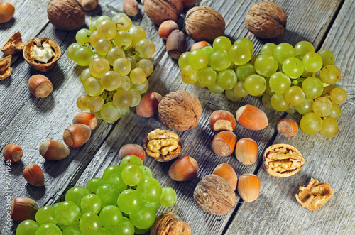 Fototapeta Naklejka Na Ścianę i Meble -  Grapeberries, hazelnuts and walnuts on a wooden table
