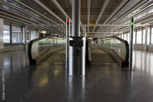 A dust bin and a pair of esclators for transporting people photo