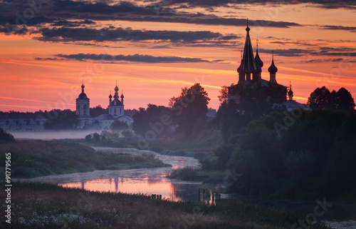 Beautiful sunrise over the churches which are reflected in the river