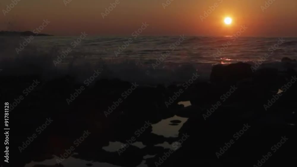 The sun sets behind beautiful ocean waves. The sun sets behind beautiful ocean waves.