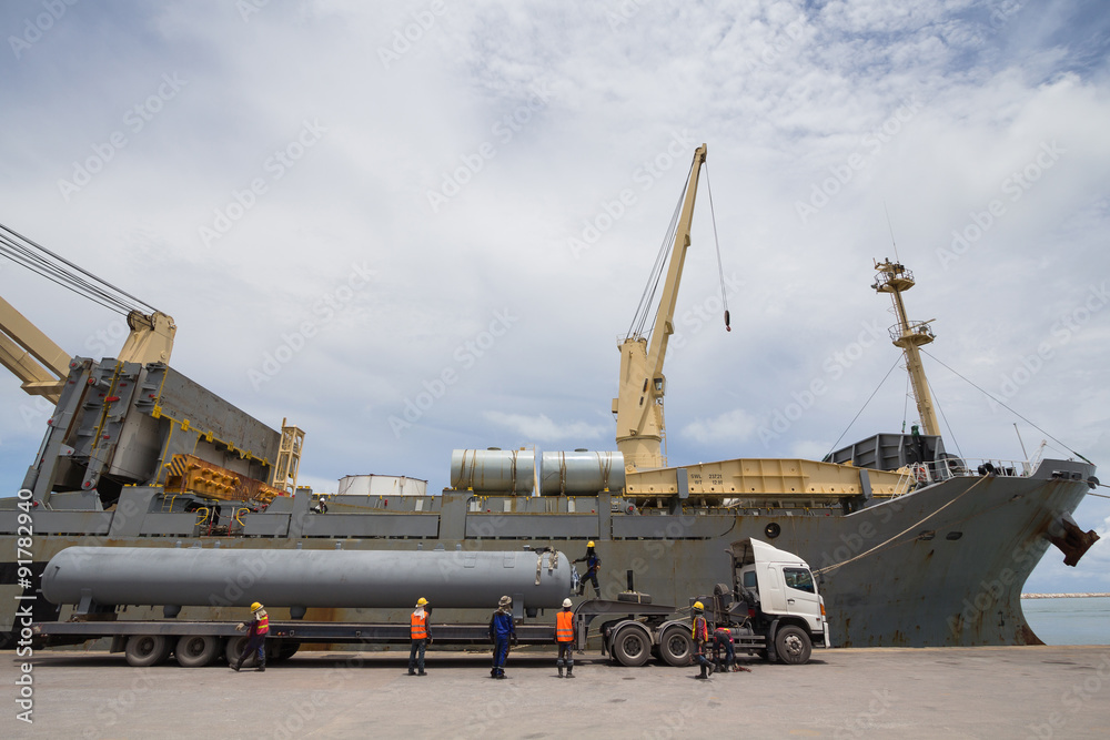 Cranes unloading a ship in a harbor
