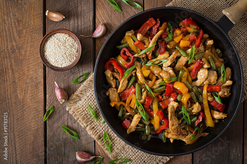 Fototapeta Stir fry chicken, sweet peppers and green beans. Top view