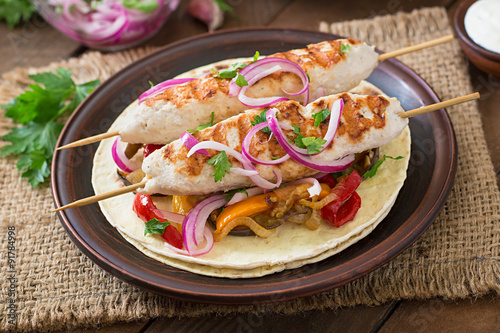 Chicken kebab with grilled vegetables and tortilla wrap.