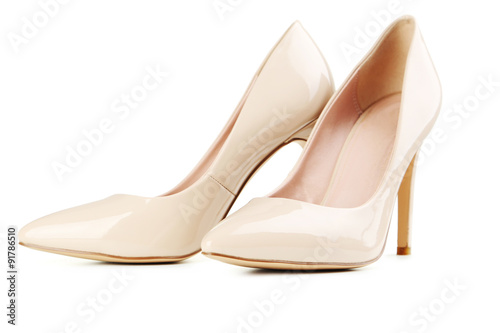 Pair of beige women's high-heeled shoes isolated on a white