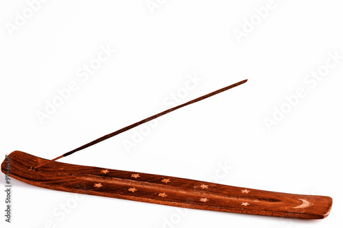 Incense stick on a wooden support on a white background