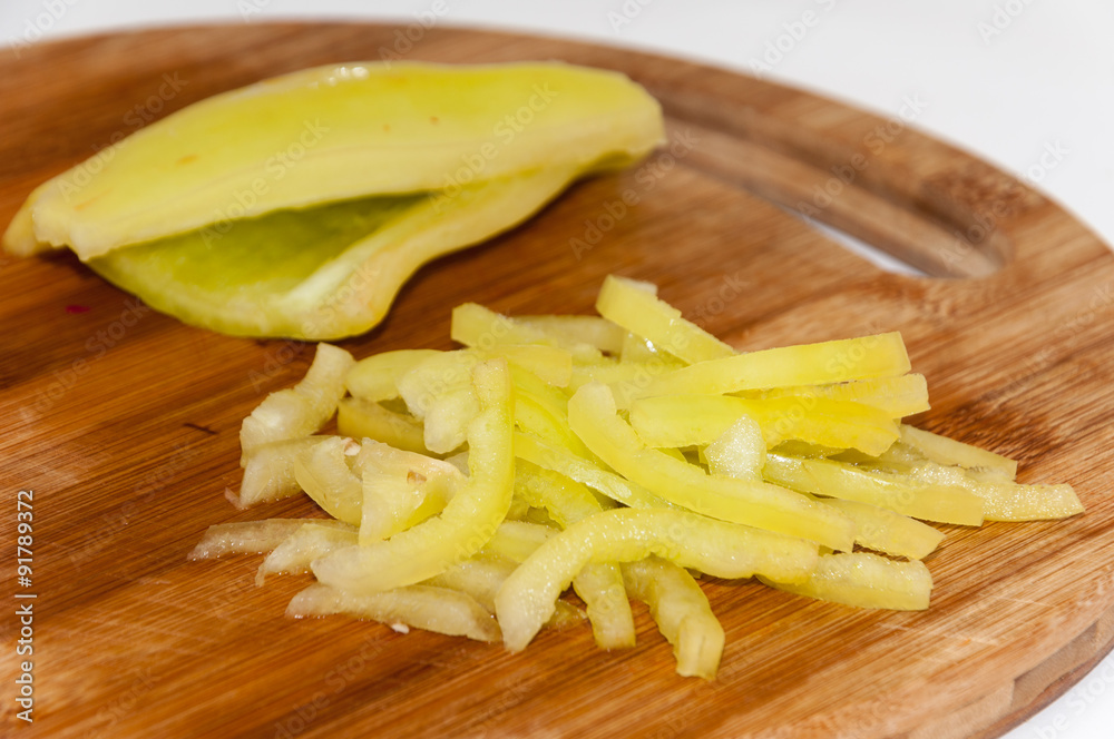 Green paprika sliced into strips on the cutting board Green paprika sliced into strips on the cutting board