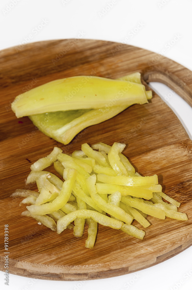 Green paprika sliced into strips on the cutting board Green paprika sliced into strips on the cutting board