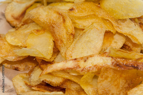 Homemade potato chips fried in deep oil