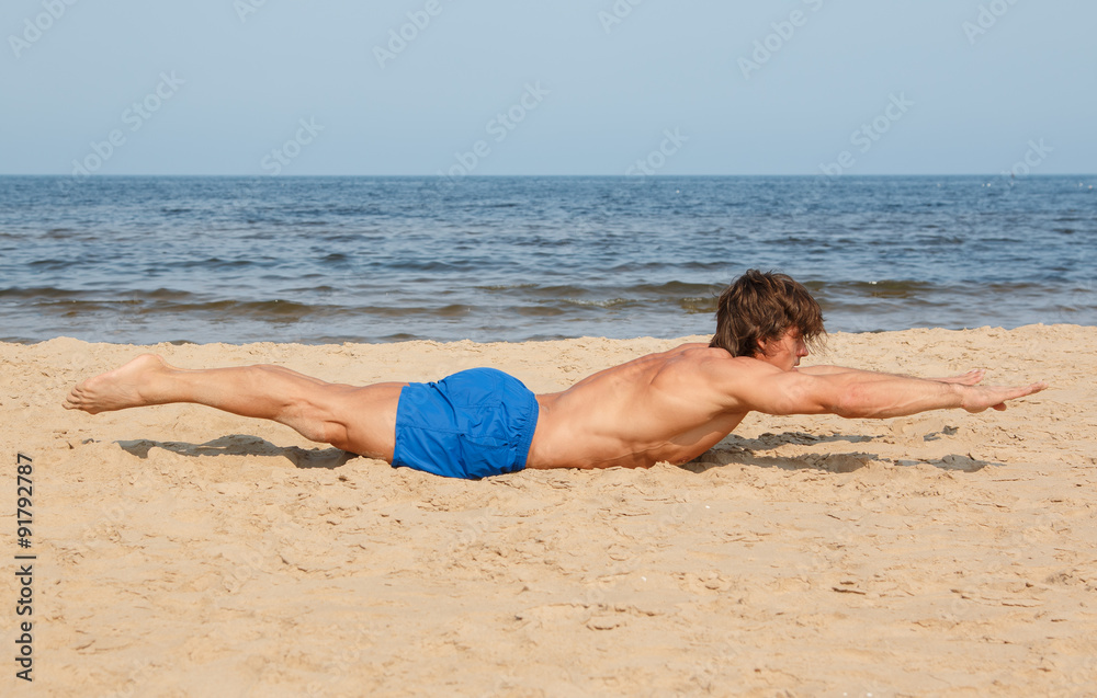 Fototapeta premium Man doing workout on the beach
