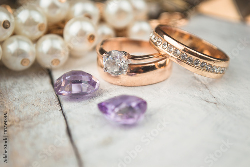 Golden wedding rings on white wood background