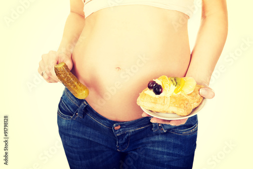 Fotografie Pregnant woman with cake and pickle