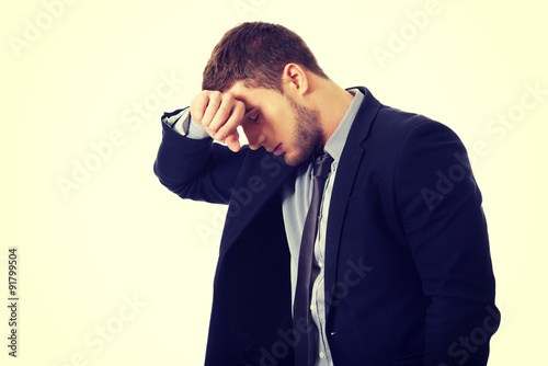 Worried businessman touching his forehead.